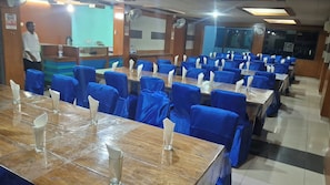 A dining area with multiple tables and chairs, a reception desk, and a person standing near the entrance. - Hotel jalico Khulna (Khulna)