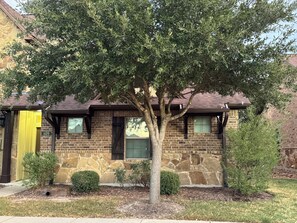 A two-story house with a stone facade, a tree in front, and a small front yard. - 3 Bedrooms - 3 Bathrooms, 7 min to Texas A&M (College Station)