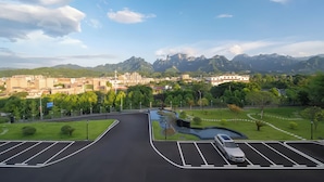 A parking area with a view of a cityscape and mountains in the distance. - Tianmen Skyview Hotel (Zhangzhou)