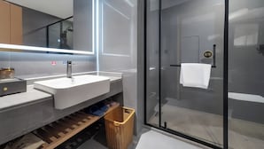 A modern bathroom with a glass shower enclosure, a white sink, and a mirror above the vanity. - Tianmen Skyview Hotel (Zhangzhou)