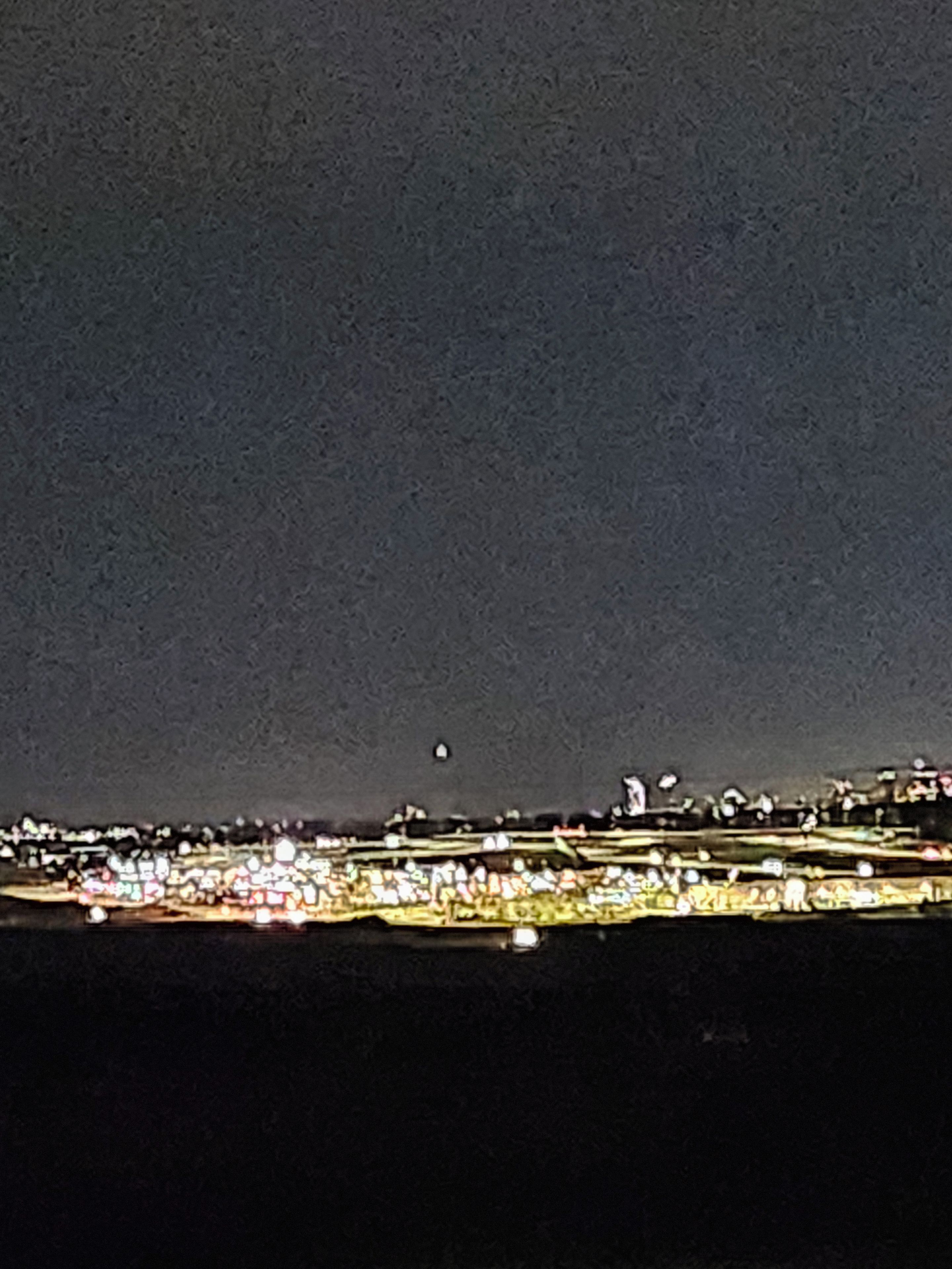 A nighttime cityscape with a view of buildings and lights.
