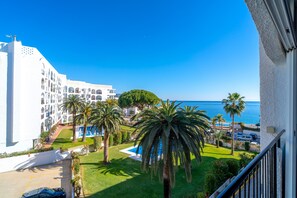 Ein Hotel mit Pool, Palmen und Meerblick.