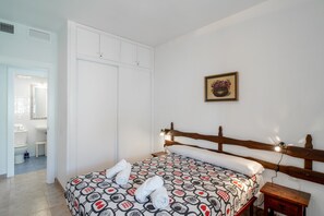 Ein Schlafzimmer mit Bett, Nachttisch, Schrank und einem Bild an der Wand.