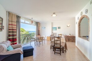 Ein geräumiger Wohnbereich mit Balkon, Esstisch und Sitzgelegenheiten.