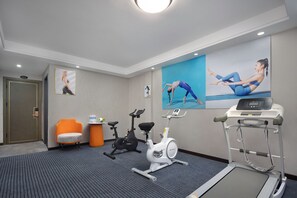 Un gimnasio con equipo de ejercicio, una cinta de correr y una bicicleta estática.