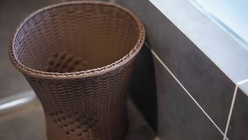 A wicker basket placed against a tiled wall.