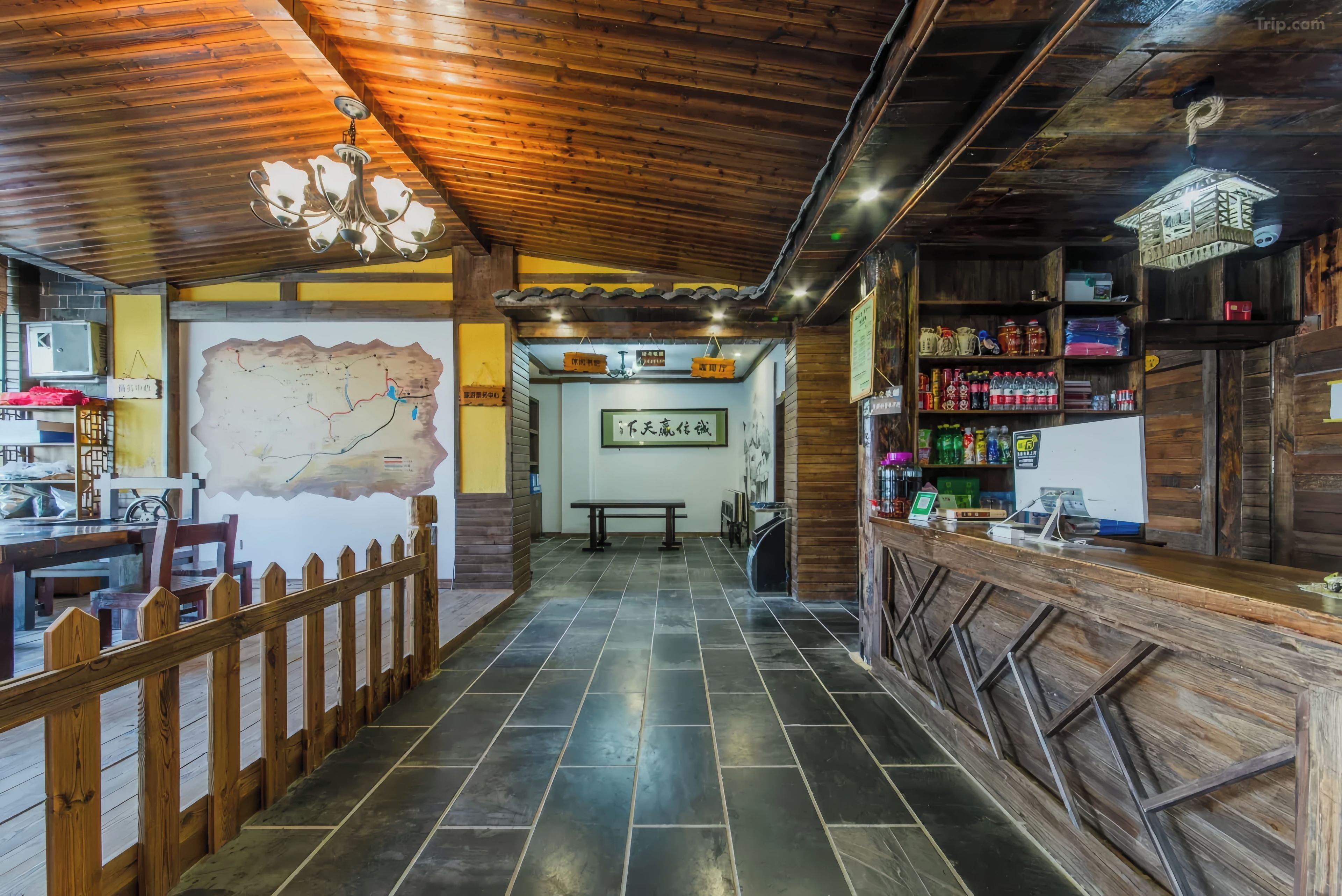 Interior de madera con un mapa en la pared, cerca de madera y mostrador con diversos objetos.
