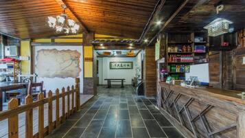 Interior de madera con un mapa en la pared, cerca de madera y mostrador con diversos objetos.