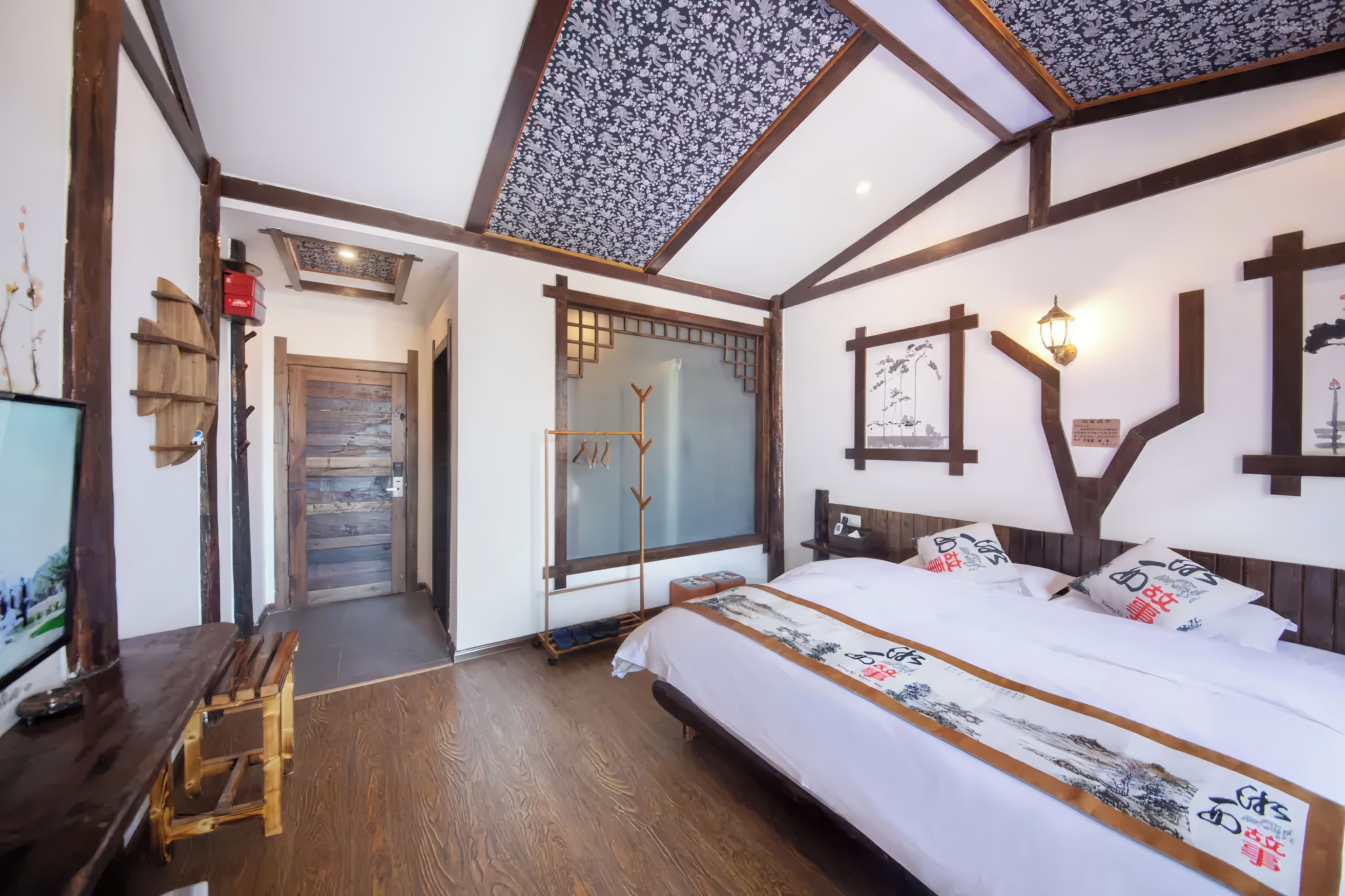 Een traditionele Japanse kamer met een bed, houten meubels en een schuifdeur.