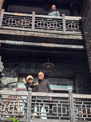 Un edificio de madera de varios niveles con un balcón.