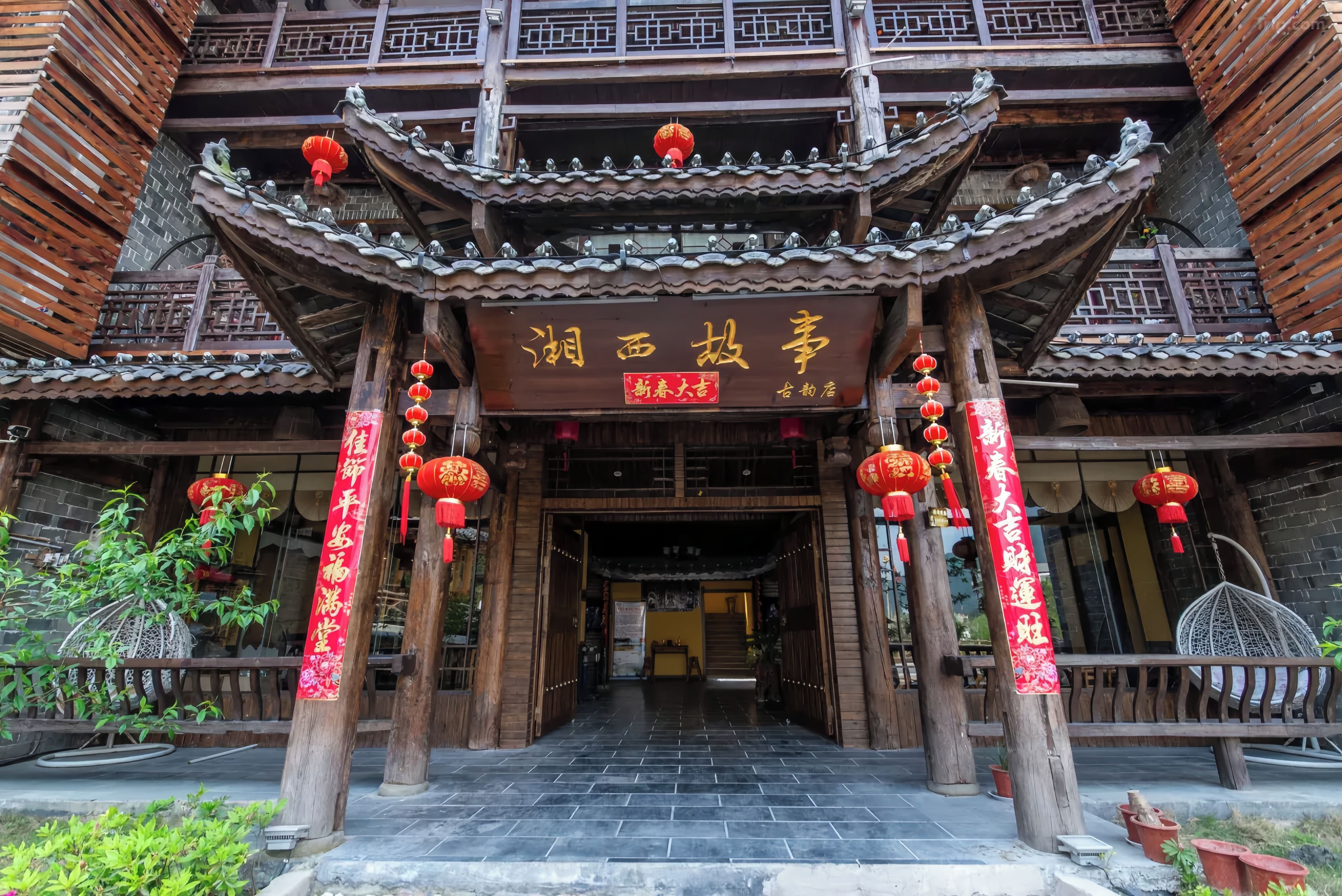 Um edifício tradicional chinês com telhado telhado, vigas de madeira e lanternas vermelhas.