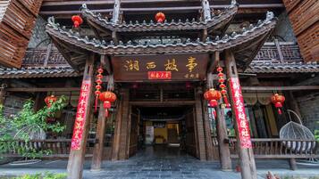 Um edifício tradicional chinês com telhado telhado, vigas de madeira e lanternas vermelhas.