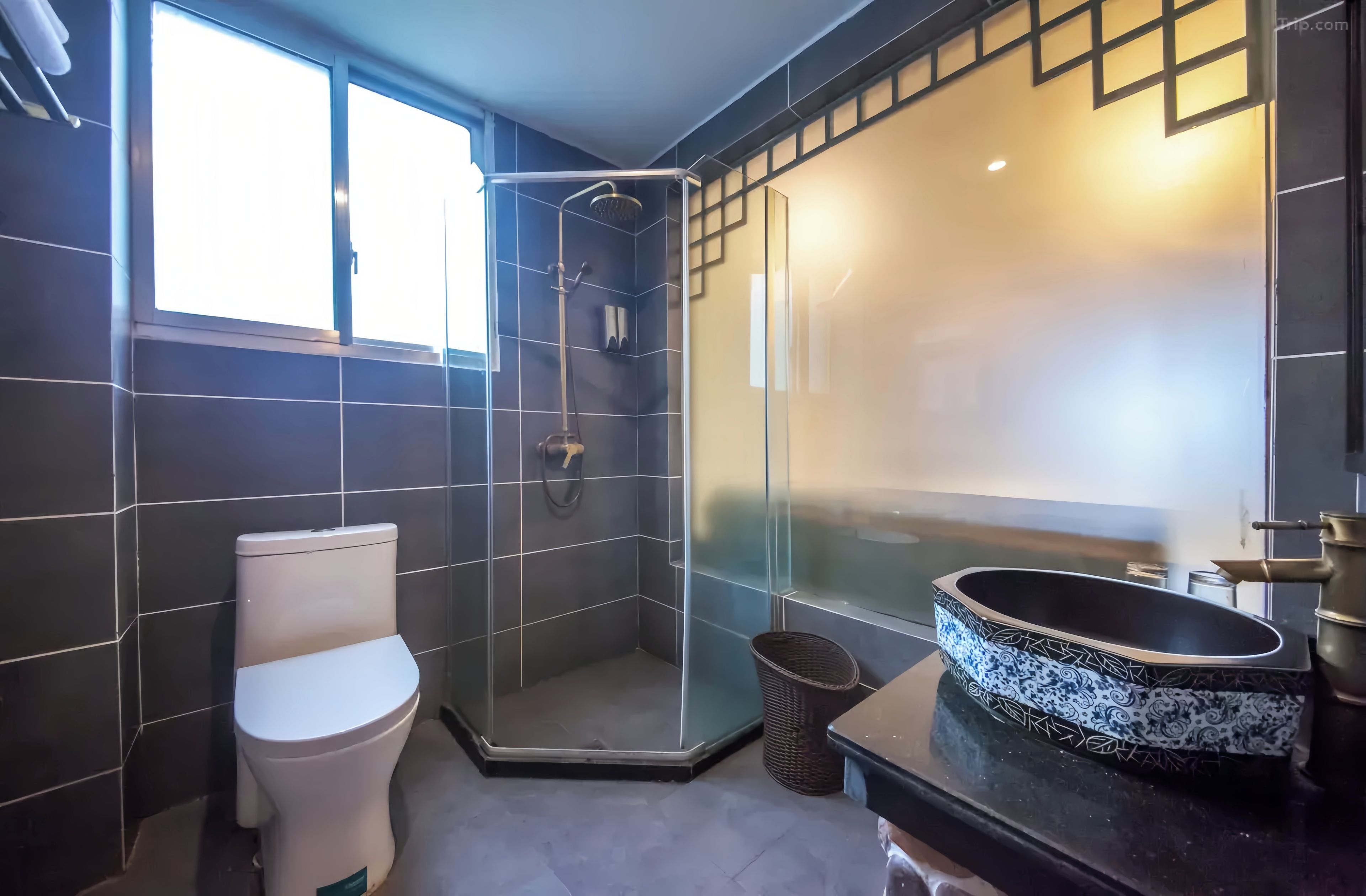 A modern bathroom with a toilet, a glass-enclosed shower, and a sink with a decorative basin.
