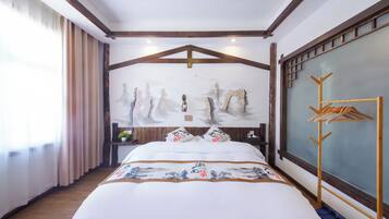 A hotel room with a bed, a wooden headboard, a wall-mounted coat rack, and a window with curtains.