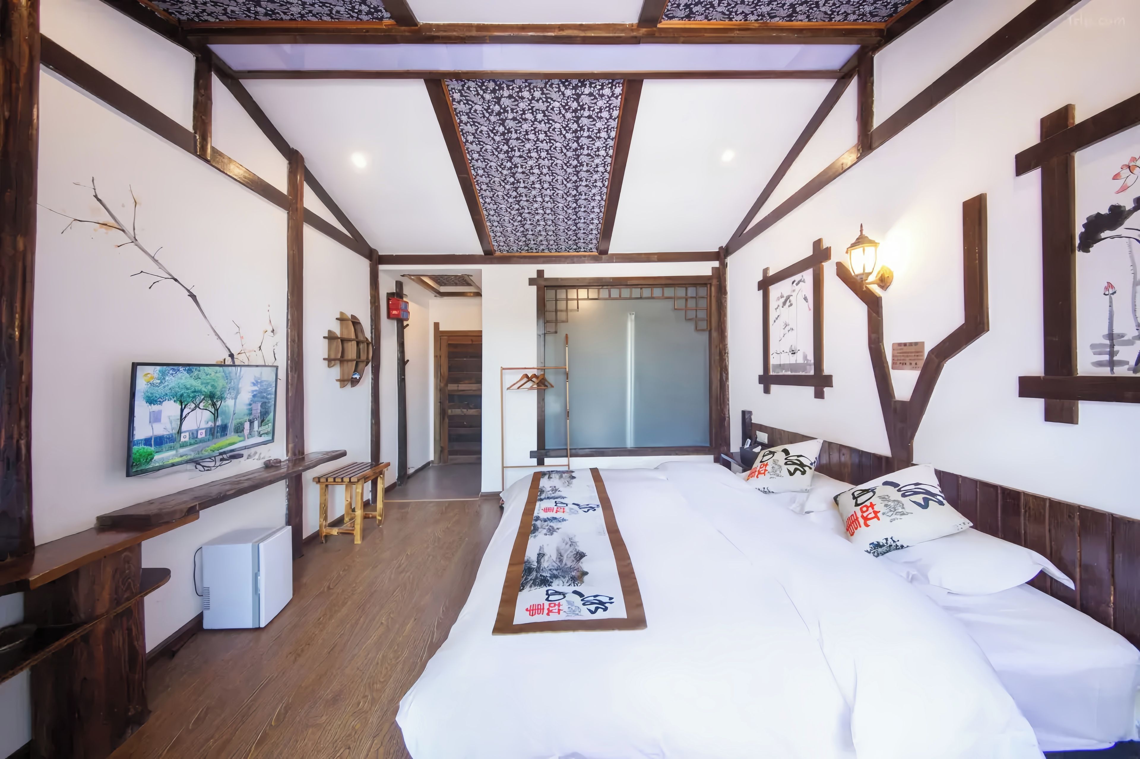 Una habitación de hotel con cama, televisión, escritorio y vistas al exterior.