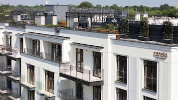 Un edificio moderno con varios balcones, un jardín en la azotea y un letrero que dice 'Cerelis'.