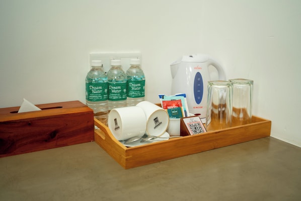 A tray with toiletries including Dream Water bottles, a Nespresso coffee pod, a glass, and a tissue box. - Rivera Tide (Bentota)