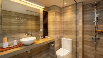 A modern bathroom with a glass-enclosed shower, a white sink, and a large mirror.