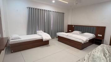 Ein Hotelzimmer mit zwei Betten, einer Marmorplatte und einem Deckenventilator.
