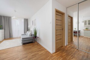 Un saló modern amb un sofà gris, una taula auxiliar petita i una planta en test.
