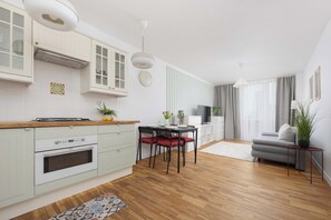 Cozinha moderna com armários brancos, bancada de madeira e forno embutido.