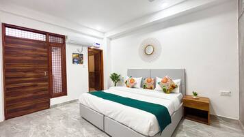 A bedroom with a bed, nightstand, and a decorative mirror on the wall.