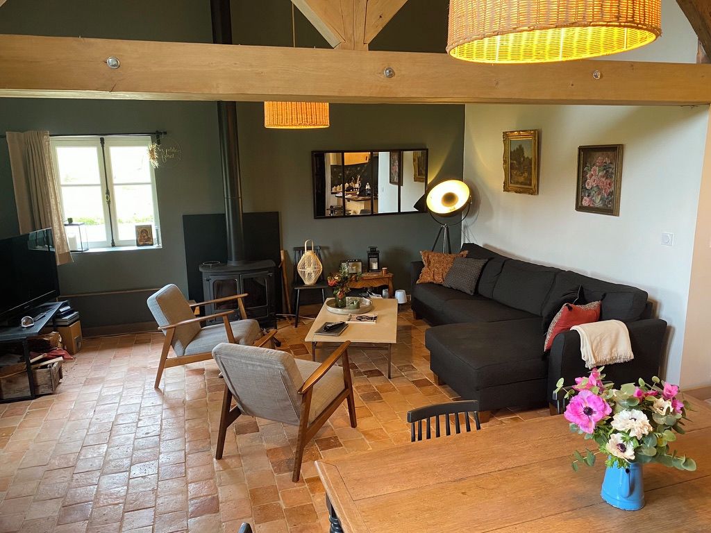 A cozy living room with a fireplace, a sofa, a coffee table, and a TV.