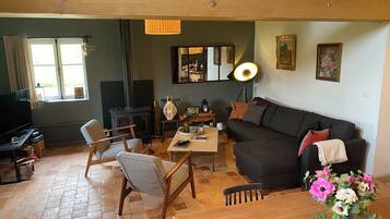 A cozy living room with a fireplace, a sofa, a coffee table, and a TV.
