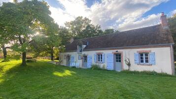 A traditional house with a brick facade, a chimney, and a well-maintained lawn.