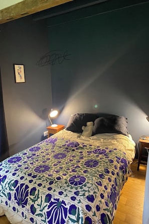 A bedroom with a bed, a nightstand, a wall with a signature, and a framed picture. - The peace and charm of the countryside (Montereau)