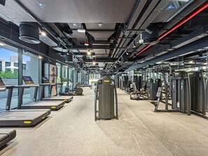 Ein Fitnessstudio mit Laufbändern, Kraftgeräten und Trainingsausrüstung.