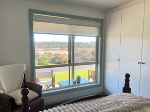 A bedroom with a large window, a bed, a chair, and a wardrobe. - My Time @ Robe - Views- Wood fire (Robe)