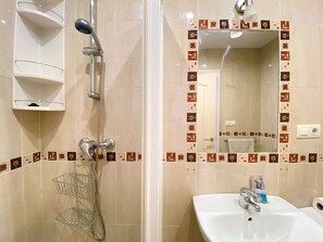A bathroom with a shower, a sink, and a mirror. - Apartment in Nerja With Sea Views & Pool (Nerja)