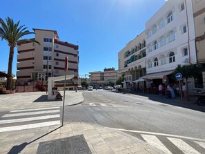 A street with buildings, a palm tree, and a crosswalk. - Apartment in Nerja With Sea Views & Pool (Nerja)