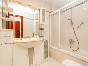 Ein Badezimmer mit Waschbecken, Spiegel, Dusche und Toilette.