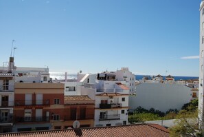 A coastal residential area with buildings, some with balconies, and a clear view of the sea. - Apartment in Nerja Near Carabeillo Beach (Nerja)