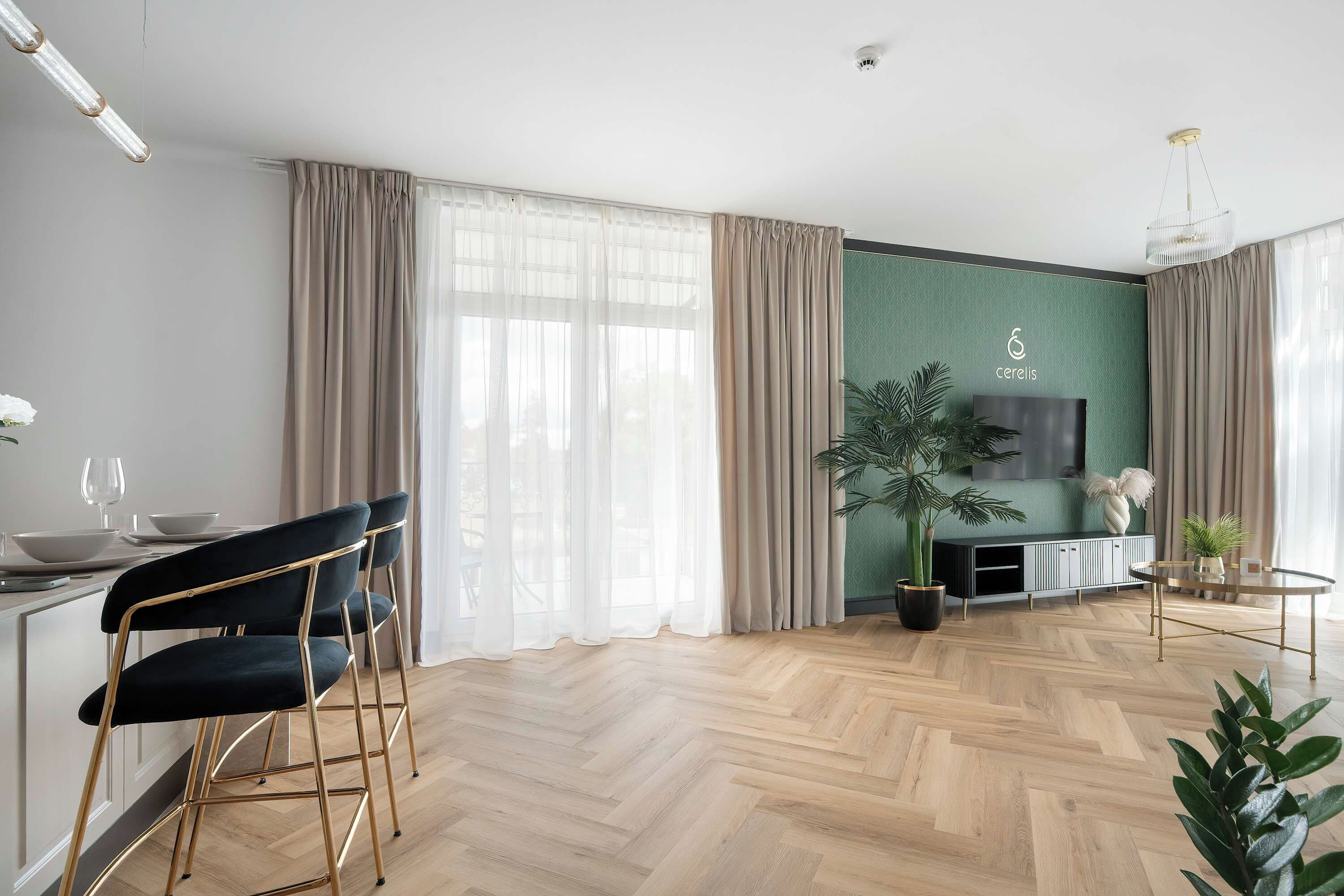 Una sala de estar moderna con piso de espiga, un comedor con mesa y sillas, y un amplio ventanal con cortinas.