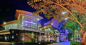 A modern building with a glass facade and the sign 'UptownParade' indicating a shopping area. - Elegant Urban Stay in Taguig City (Taguig)