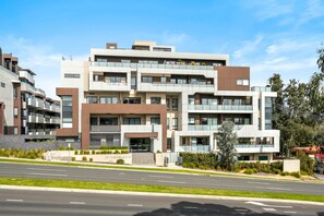 A multi-story residential building with a modern architectural design, featuring balconies and large windows. - Seednest Modern Apt by Mall, BBQ & Parking (Doncaster East)