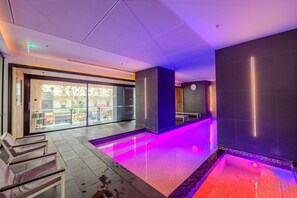A modern indoor pool area with a glass wall, a bench, and a clock on the wall. - Stay in the Heart of Melbourne CBD-Walk Everywhere (Melbourne)