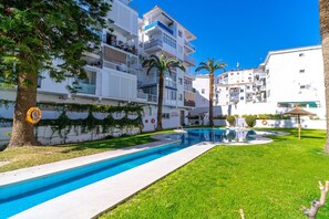 A residential building with a swimming pool, palm trees, and a clear blue sky. - Studio in Nerja Near Torrecilla Beach (Nerja)