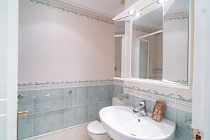 A bathroom with a white sink, a toilet, and a shower area. - Studio in Nerja Near Torrecilla Beach (Nerja)
