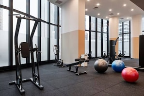 A gym with exercise equipment, large windows, and a view of buildings. - LVL 56 City Skyline | Stylish 3B Apt w/ Pool & Gym (Melbourne)