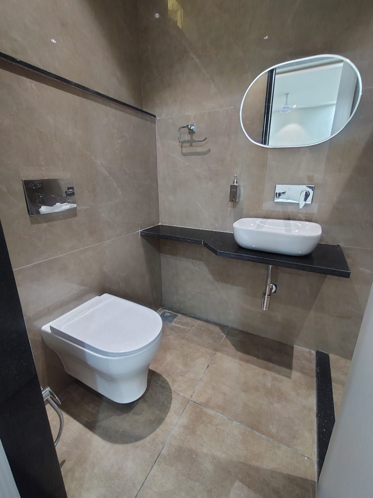 A modern bathroom with a toilet, a sink, and a mirror.