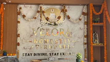 A marble wall with gold lettering and a central emblem, surrounded by floral garlands.
