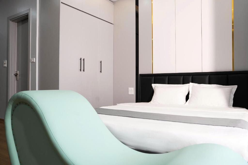Un dormitorio con cama, una silla y un armario.