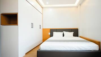 A modern bedroom with a bed, a wardrobe, and a built-in shelf.