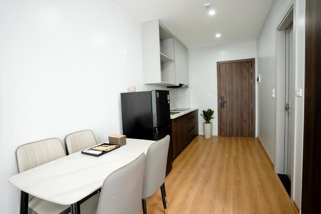 A compact kitchen with a refrigerator, a microwave, and a wooden door.