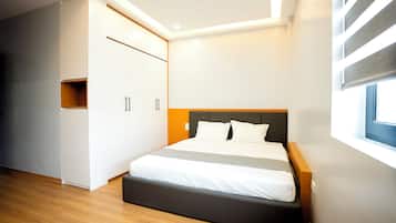 A modern bedroom with a bed, built-in wardrobe, and a window.