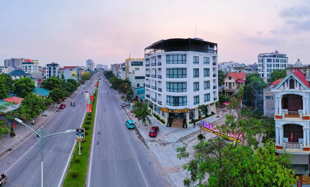A multi-story hotel with a modern design, located on a busy street with visible signage for the hotel and nearby businesses.